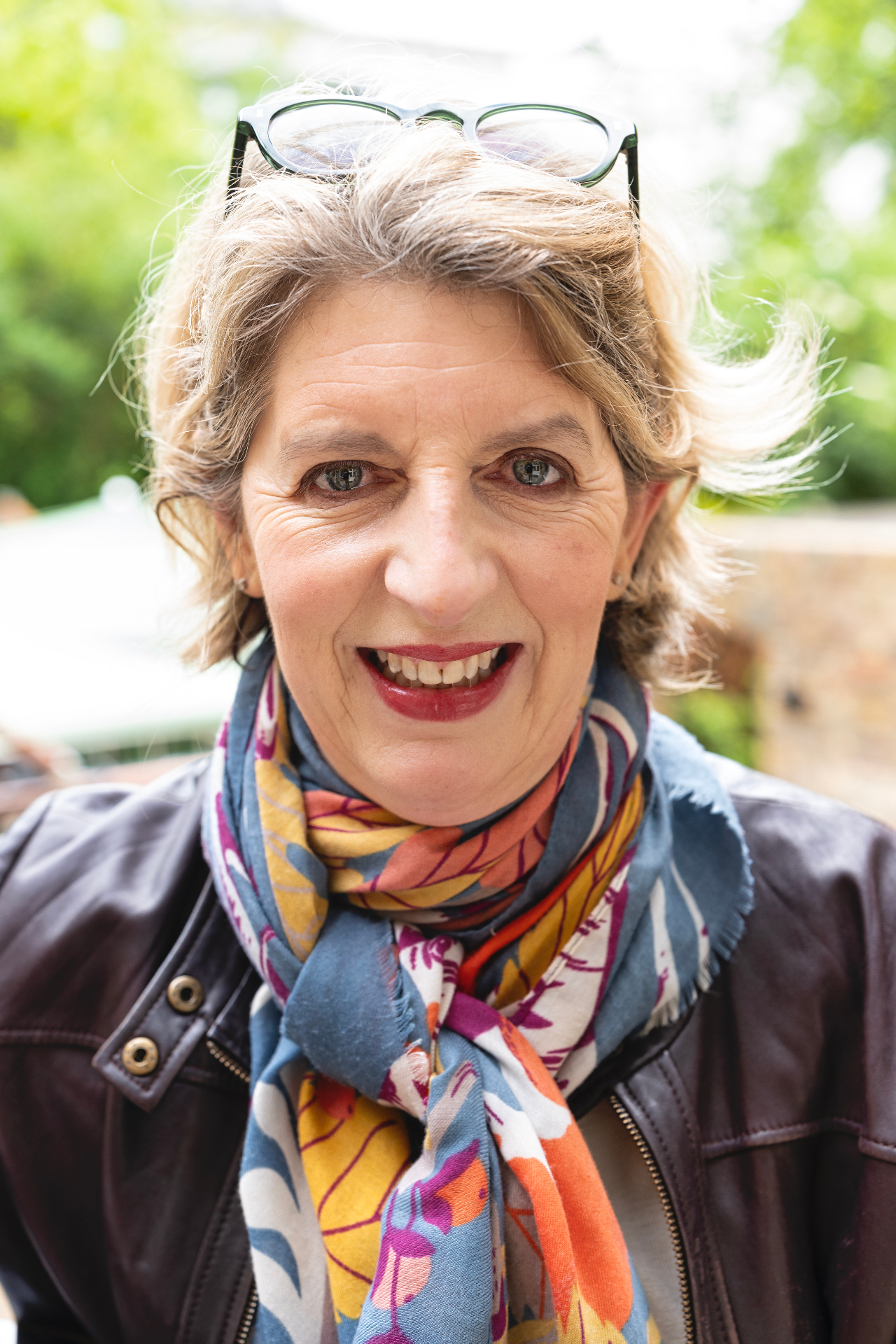 Headshot of Louise Ballard wearing a leather jacket and patterned scarf