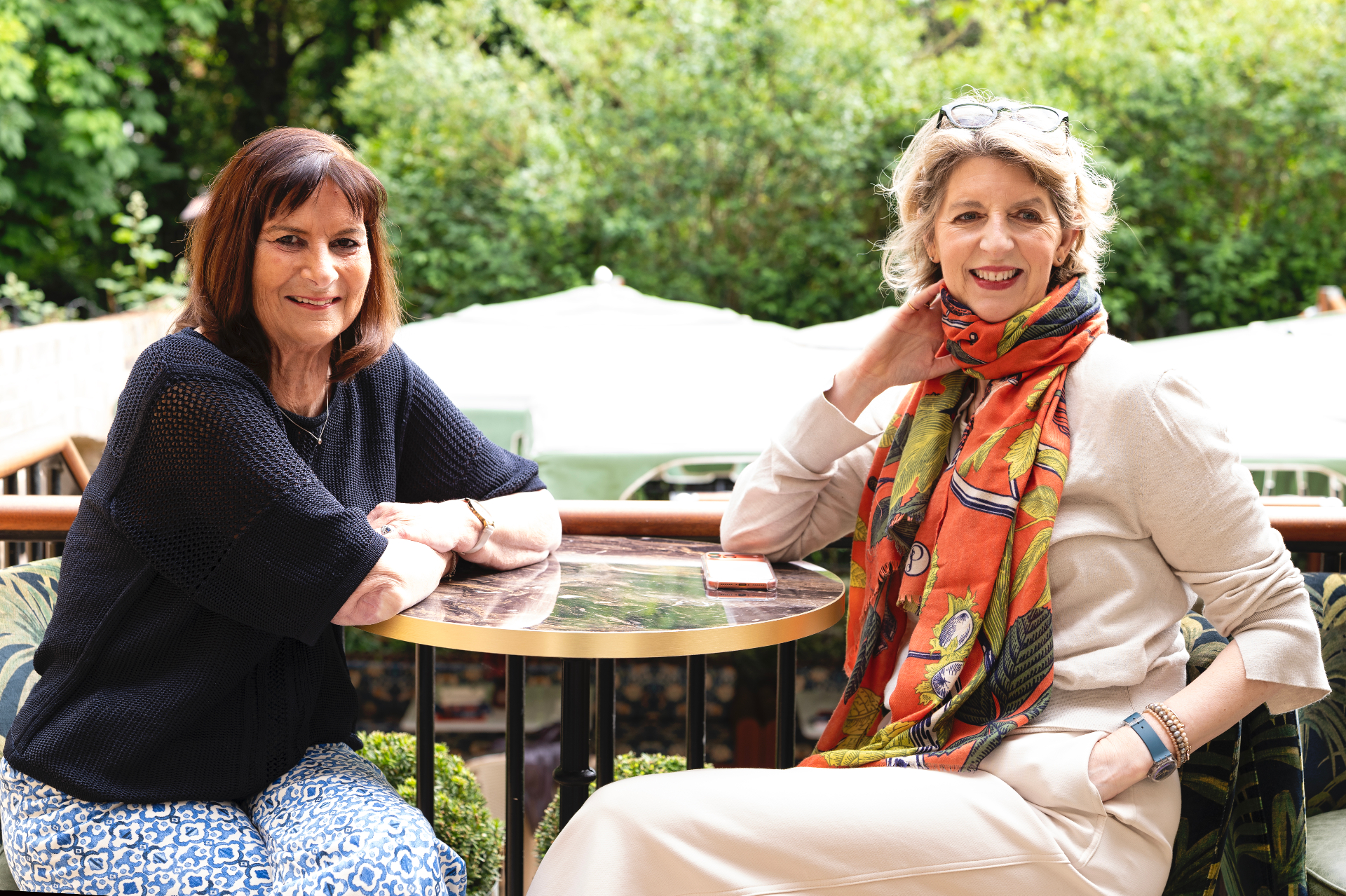 Louise Ballard and Victoria Tomlinson seated outdoors for a media portrait